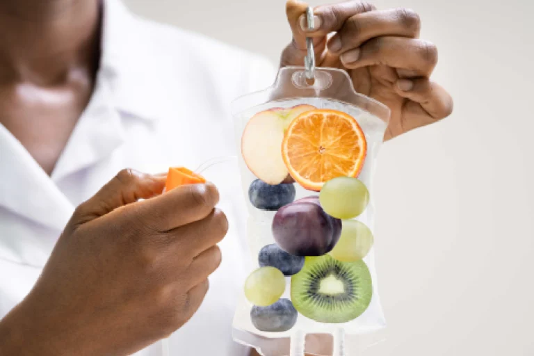 Medical professional holding a vitamin-infused IV bag with fruits inside representing IV Hydration in Kenai, AK
