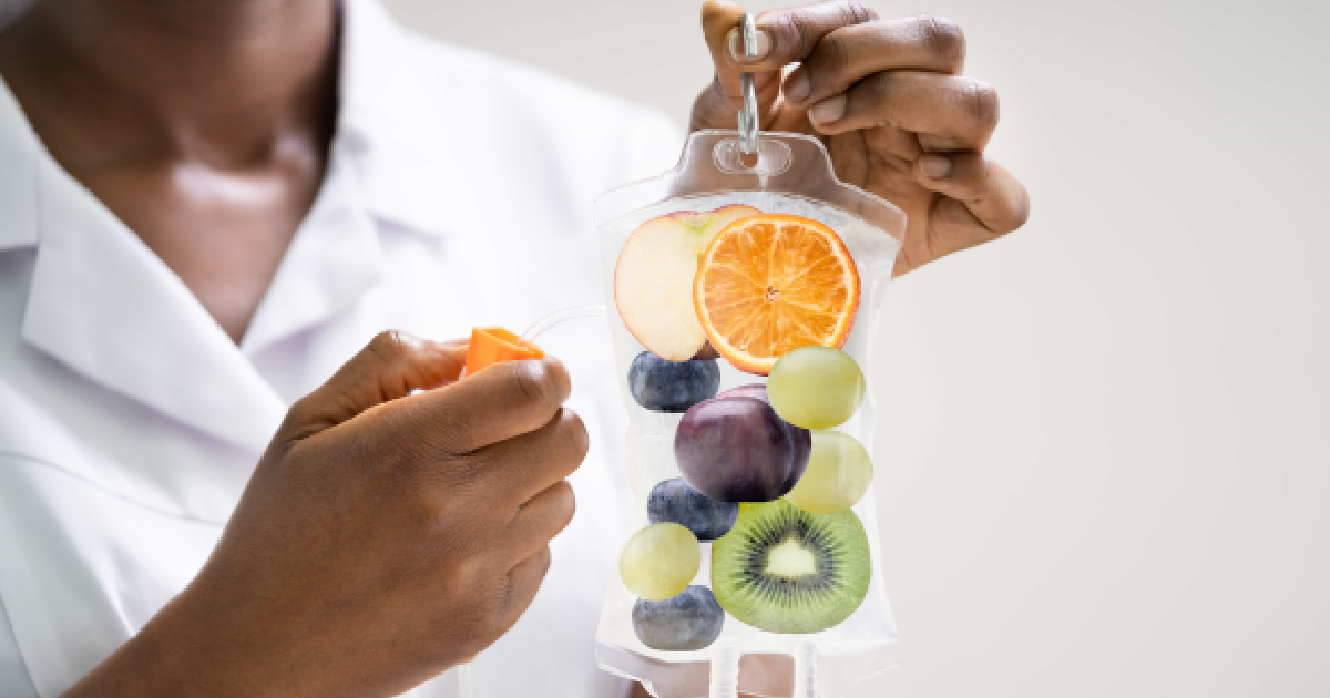 Medical professional holding a vitamin-infused IV bag with fruits inside representing IV Hydration in Kenai, AK
