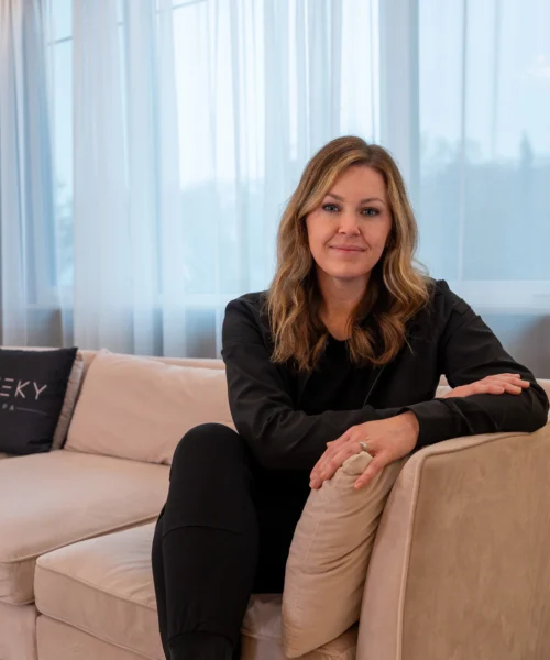 Licensed aesthetic provider seated in a modern medical spa consultation area