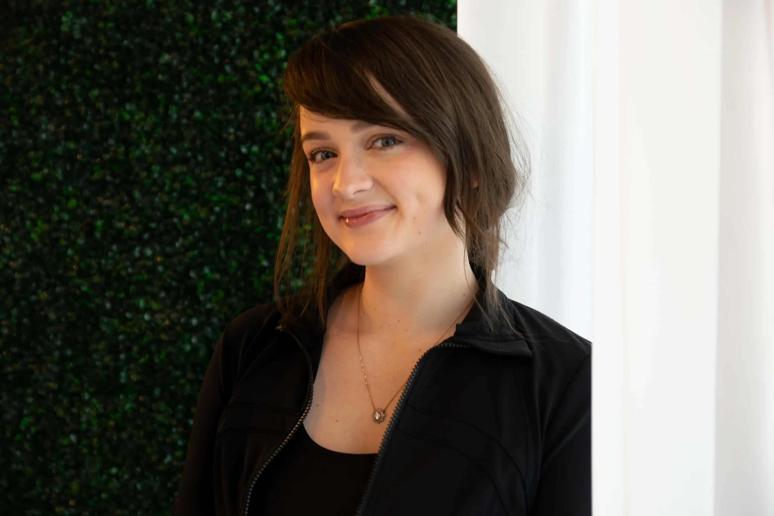 Friendly medical spa receptionist welcoming guests at the front desk in a modern clinic